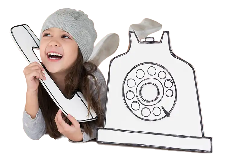 Radosna dziewczynka w szarej czapce, udająca rozmowę przez duży, kartonowy telefon, co dodaje zabawnego i kreatywnego akcentu do obrazu.